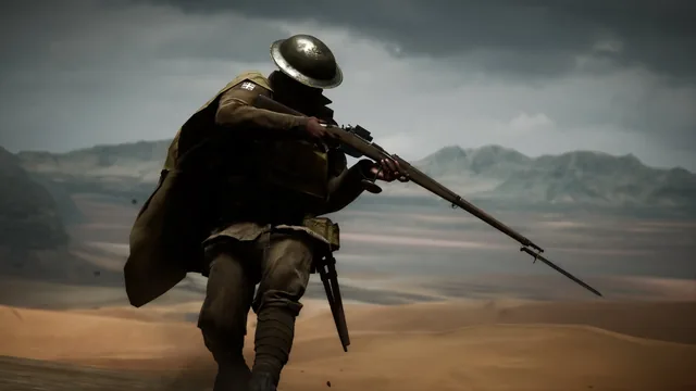 A British soldier advancing with a rifle across desert dunes